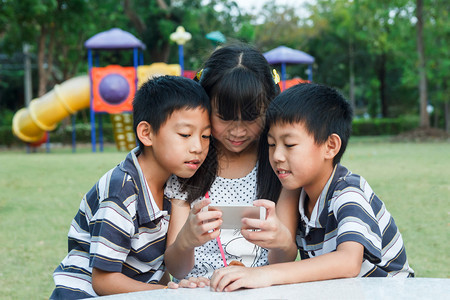 微笑姐妹和双兄弟用智能手机玩乐坐人们图片
