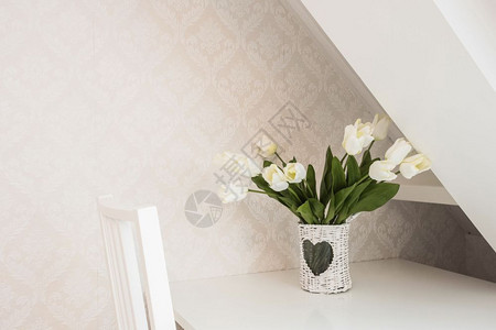 爱房间天白色现代客房书桌上花瓶中的白玫瑰插花带图案墙纸的白色现代客房书桌上花瓶中的白玫瑰图片