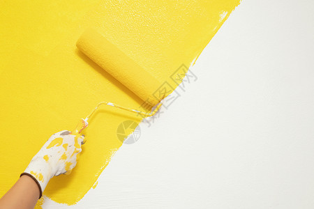 油漆刷关闭地墙壁上手工画家人的绘用黄色彩涂漆公寓进行翻新留下空复制间在外边写描述文字工具修理内部的图片