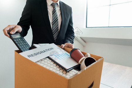 在棕色纸板盒和辞职信上携带包装个人公司的商因辞职或离失业辞概念而或更换工作失业和辞职的信或者工人保持图片