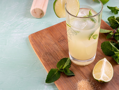 人们柠檬汽水莫吉托鸡尾酒包括石灰薄荷叶冰块和银摇晃器Shaker柠檬石灰薄荷叶和用于夏季鸡尾酒的冰新鲜图片