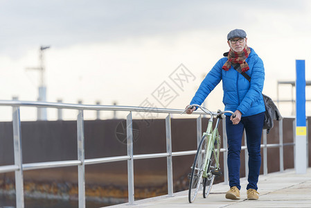 骑自行车时髦的步肖像老人骑着自行车在海边走图片