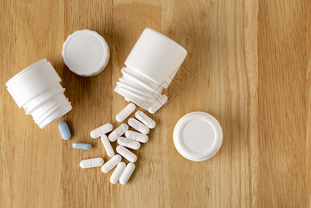 一个医疗装置塑料白色和玻璃瓶木桌上的药用蓝色和白丸用蓝和白丸复制一种治疗图片