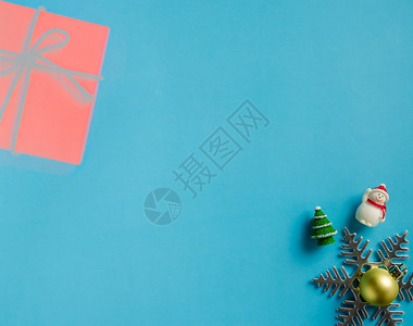 平坦的躺着闪亮蓝纸背景雪人花圣诞金球和fir树的圣诞装饰品背景带有复制空间设计的平板布局图片