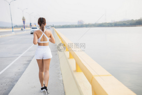 女户外为了参加马拉松运动锻炼训练演习以在公路上健康地开展体育娱乐活动在街头进行运动锻炼培训时妇女运动员通过锻炼图片