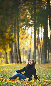 在秋天公园的草地上坐着美丽的女孩户外白种人套图片