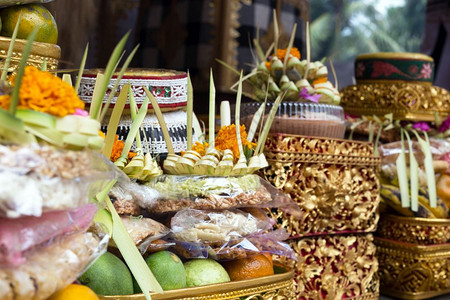 亚洲人灵供品向印度尼西亚神灵赠送传统祭品在寺庙中献花水果和香棒向印度尼西亚神教徒献送佛巴厘传统祭品在寺庙里献花水果和香棍图片