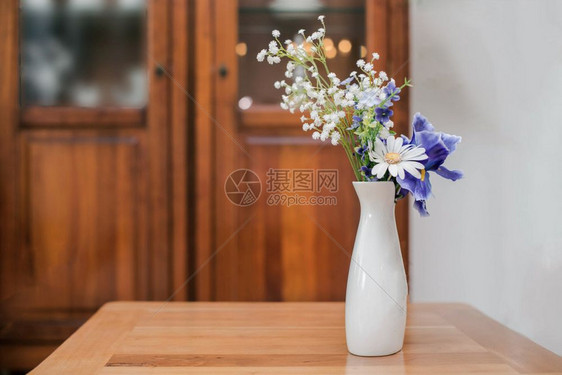 简单的花客厅里白色瓶的在桌子上特写复古设计在客厅里的白色花瓶在桌子上特写柔软的图片