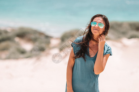 年轻美丽的女人在热带海滩度假期间白色热带海滩上的年轻美丽女人岩石松弛士图片