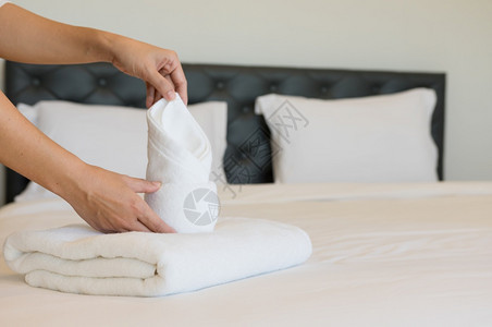 年轻的旅馆女青把软毛巾床铺和放在一家旅馆清洁工身上放在床干净的白毯子早卧室有枕头软毛巾清洁器女佣曾是图片