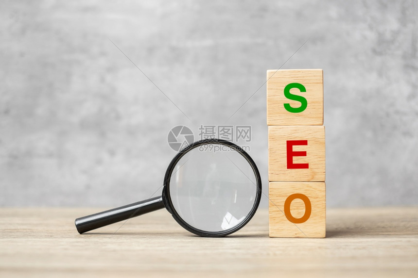 保持排行信息SEO搜索引擎SEO最佳优化文本木立方块和手握表Idea战略广告营销关键词和内容概念上的放大玻璃图片