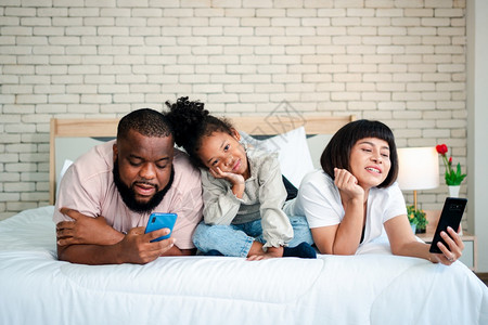 躺在床上看手机的一家人图片
