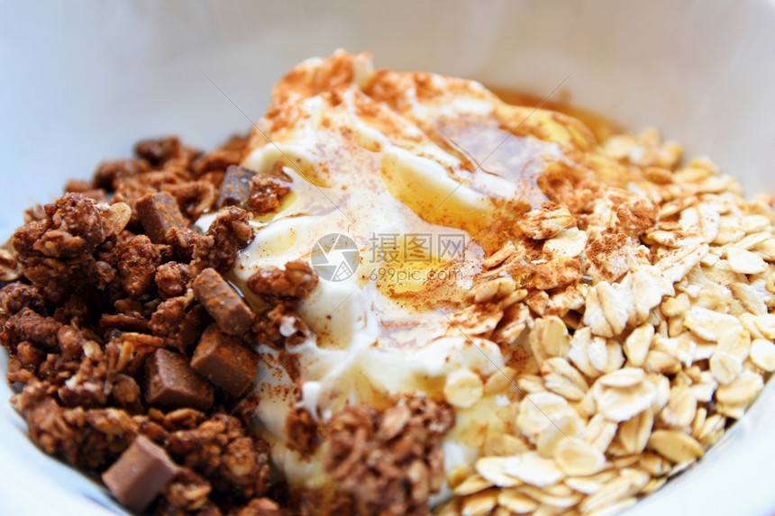 水果早晨健康食品在梅斯利酸奶含巧克力的燕麦蜂蜜和肉桂白菜中吃早餐勺子图片