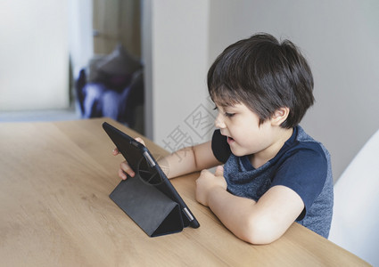 在桌上使用平板电脑的小男孩图片