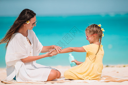 和母亲在沙滩边玩耍的小女孩图片