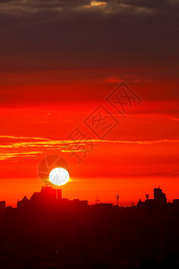 颜色地标清晨阳光明亮的太以红光照射天空升至沉睡城市垂直图象房屋的轮盘上方复制空间清晨在城市房屋垂直图象的轮椅上一个明亮的红色太阳图片
