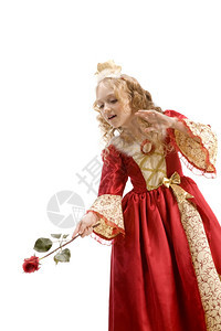 美丽的小女孩长金发穿着公主服装红玫瑰像魔杖般的红玫瑰在白色背景的红和金帝国礼服仙女童年俏皮图片