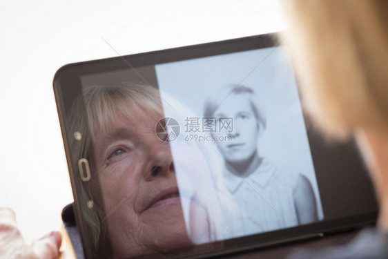 应用在平板电脑主题上观看自己旧照片的高级天主教妇女与老龄化过程怀旧和童年形成对比7081药片退休图片