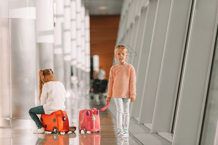 在大国际机场的可爱小女孩准备度假舒适小女孩在机场玩得开心坐在行李箱上等登机等待登机的好女孩手提箱飞机场图片