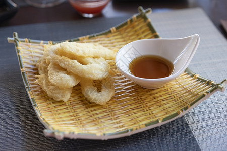 食物伊卡IkaFurai深炸鱿鱼环涂在面粉包屑中配有酱油和背景辣椒午餐图片