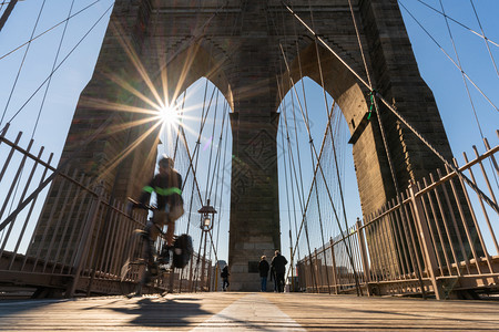标志人们大都会美国市区天际建筑和与旅游观光概念日出时由布鲁克林桥搭载的停运动自行车场景图片