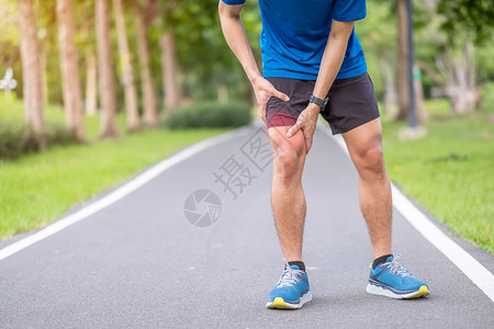 由于IliotibialBandal综合症ITBS运动受伤和医疗概念在跑步过程中肌肉疼痛的年轻男子腿到期的髂胫束乐队图片