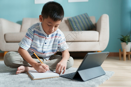 笔记本数字的教育亚洲男孩与在线教师一起家里学习和做庭作业使用平板电脑上网教学老师图片