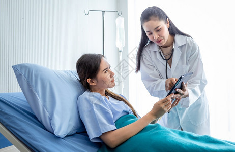 医生用平板电脑向年轻女患者讲解病情图片