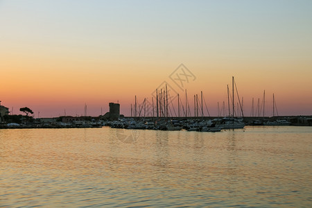 完美的码头结石日落时停在意大利埃尔巴岛Marciana小港口的船舶图片