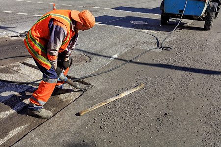 施工现场道路维修人在施期间用气动手提钻清除旧沥青工人在道路施期间用气动手提钻清除部分沥青铺外部图片