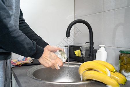 消毒剂持水槽自来清洗食物在中用肥皂清洁消毒到厨房的家中进行消或污染的无名caucasian男子手中的侧面观点男人图片