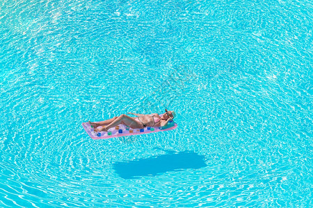 穿比基尼的姑娘在豪华酒店户外泳池里美少女在游泳池里放松她正在游泳池里放轻松成人日光浴美丽的图片