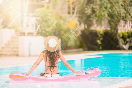 马尔代夫穿比基尼的姑娘在豪华酒店户外泳池里美少女在游泳池里放松她正在游泳池里放轻松床垫田园诗般的图片