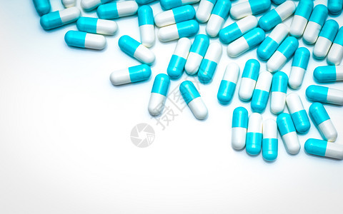 白色的药品背景上的蓝抗生素胶囊丸用于医疗保健主题的彩色胶囊丸制药业抗生素耐概念抗菌物剂学医疗的图片