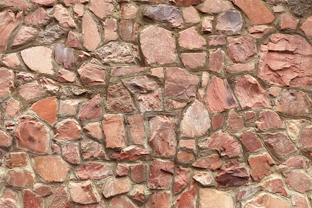 建筑学砖砌墙由天然粗糙的红花岗岩和刺绣的水泥边界组成墙是由天然粗嫩的红花岗岩组成偏长石图片