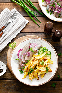 欧米加3用洋葱和油炸土豆在盘子上提取的火辣片挪威传统的图片