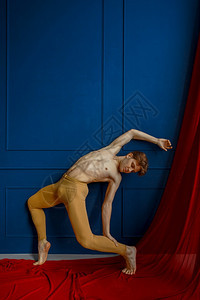 工作室男芭蕾舞者在蹈课的蓝墙上穿色壁背景表演者穿着红色衣服肌肉有优雅和的运动芭蕾舞者在蹈课的蓝墙上穿色有氧运动跳图片
