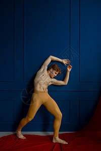 移动行男芭蕾舞者在蹈课的蓝墙上穿色壁背景表演者穿着红色衣服肌肉有优雅和的运动芭蕾舞者在蹈课的蓝墙上穿色时尚图片