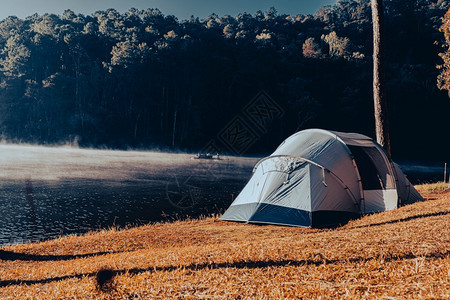 在黎明时分宁静旅游与自由的概念下在一个美丽的湖边迷雾河上露营帐篷隐私风景反射图片