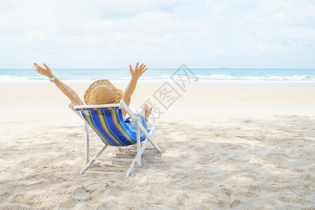 蜜月快乐的年轻美丽亚洲年轻女在海边滩上坐着椅子轻松放享受观视海洋的景象暑假和旅行期概念中蓝天和色空海滨图片