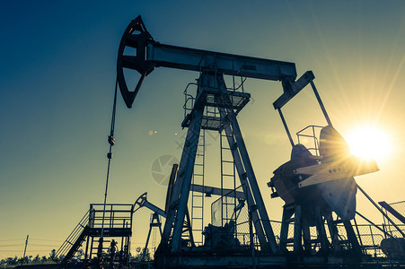 钻机经济的活力油泵在日落天空背景的工业设备用于提取石油的摇摆机采矿石油概念泵工业设备图片