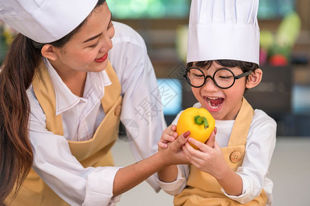 喜欢做饭的亚洲快乐小男孩厨师在家庭房里很搞笑的母亲烹饪人们的生活方式和家庭自制食物配料概念蔬菜沙拉制作人们的生活方式和家庭自制食图片