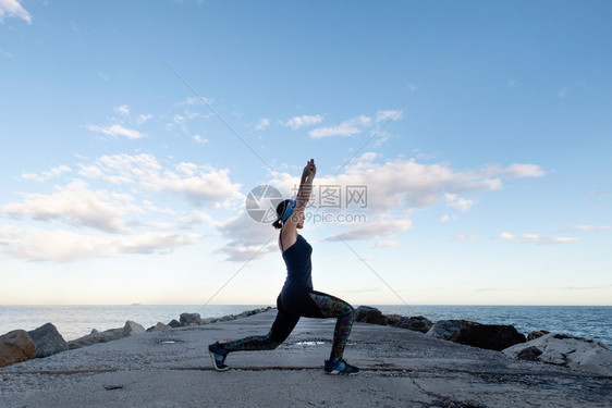 女人在阴云的一天海滩上做瑜伽多云的运动宁静图片