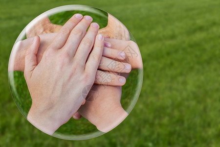支持友谊携起手来加入在绿草上隔绝的玻璃球分享图片