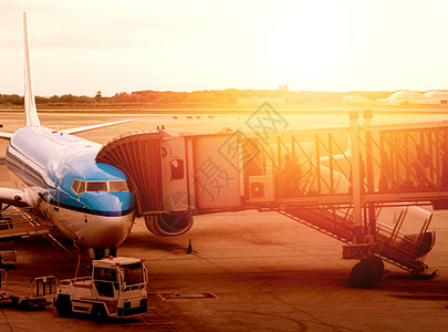 空气服务门连接商用飞机身的喷气式桥使旅行者能够在日落时国际机场登上乘客业务在黄昏时搭乘旅客登机图片