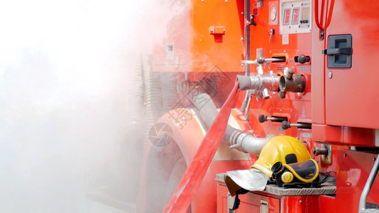 氧工人消防员用水管化学泡沫喷洒剂发动机与火焰战斗的消防员Fierman戴硬帽身穿防火灭器方面的营救训练制服抵抗的背景图片