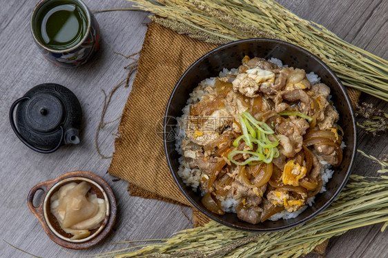 日本猪肉饭碗配鸡蛋和洋葱Donburi在木桌日本菜风格上配有姜咸菜和绿茶日本人麻布饮食图片