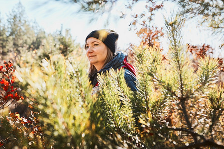 徒步旅行在阳光明媚的节假日享受远足的妇女背在森林中行走的女勘探乐趣图片