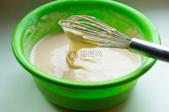 用于在绿色碗中烘烤的面团搅拌用于煎饼的面团搅拌用于煎饼的面团用于在绿色碗中烘烤的面团桌子糖果牛奶图片