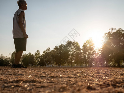 成人运动服积极的亚洲高年长男子在日落天空背景的公园里慢跑健康生活方式和保健概念图片